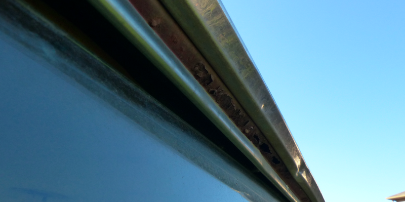 Rust holes around the rear glass.